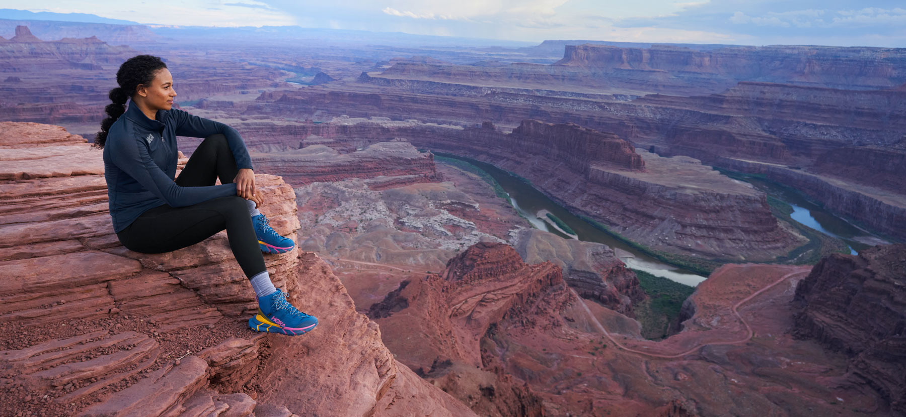 woman sitting above the grand canyon